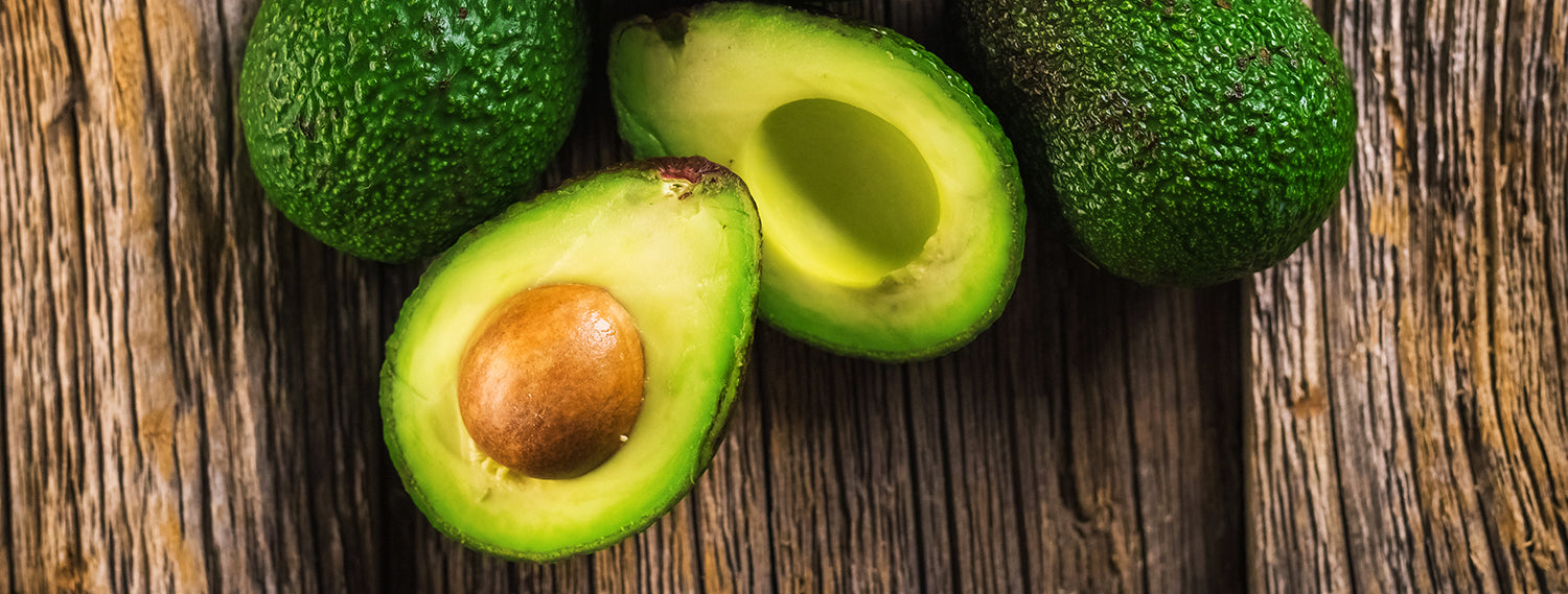 Avocados on wooden background